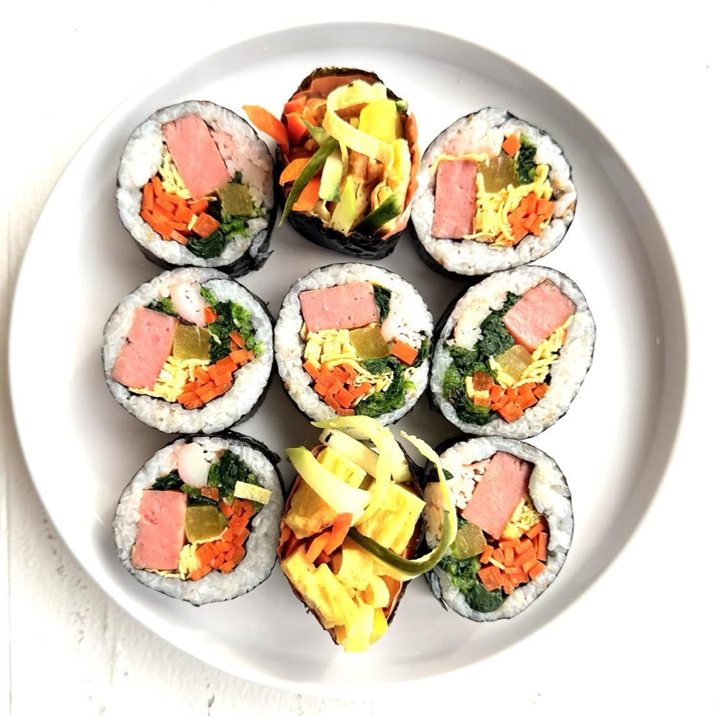 Official photograph of signature SPAM Kimbap beautifully arranged on white plate at Broad Bunsik in Palisades Park