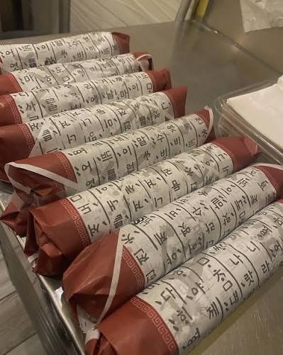 Traditional paper-wrapped takeaway gimbap rolls at E-Mo Kimbap