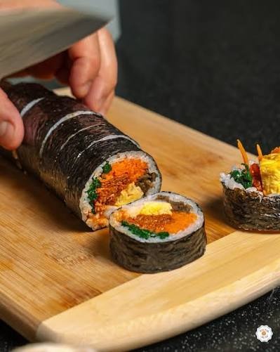 Historical photograph of artisan gimbap roll being sliced at TBD Gimbap pop-up